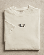 Folded view of LUUM’s “Dreamer and the Doer” off-white Supima t-shirt featuring dragon and tiger duality design. Part of Threadmark Collection. Belief. Woven and Worn.