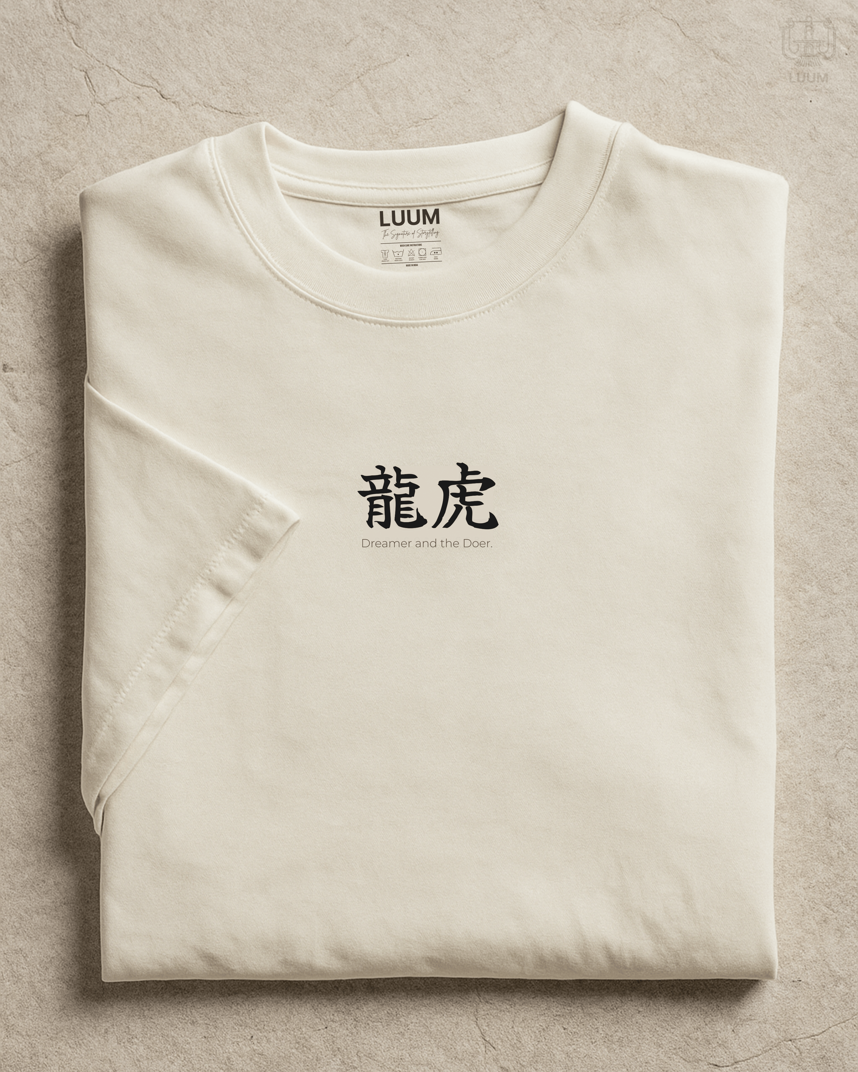 Folded view of LUUM’s “Dreamer and the Doer” off-white Supima t-shirt featuring dragon and tiger duality design. Part of Threadmark Collection. Belief. Woven and Worn.