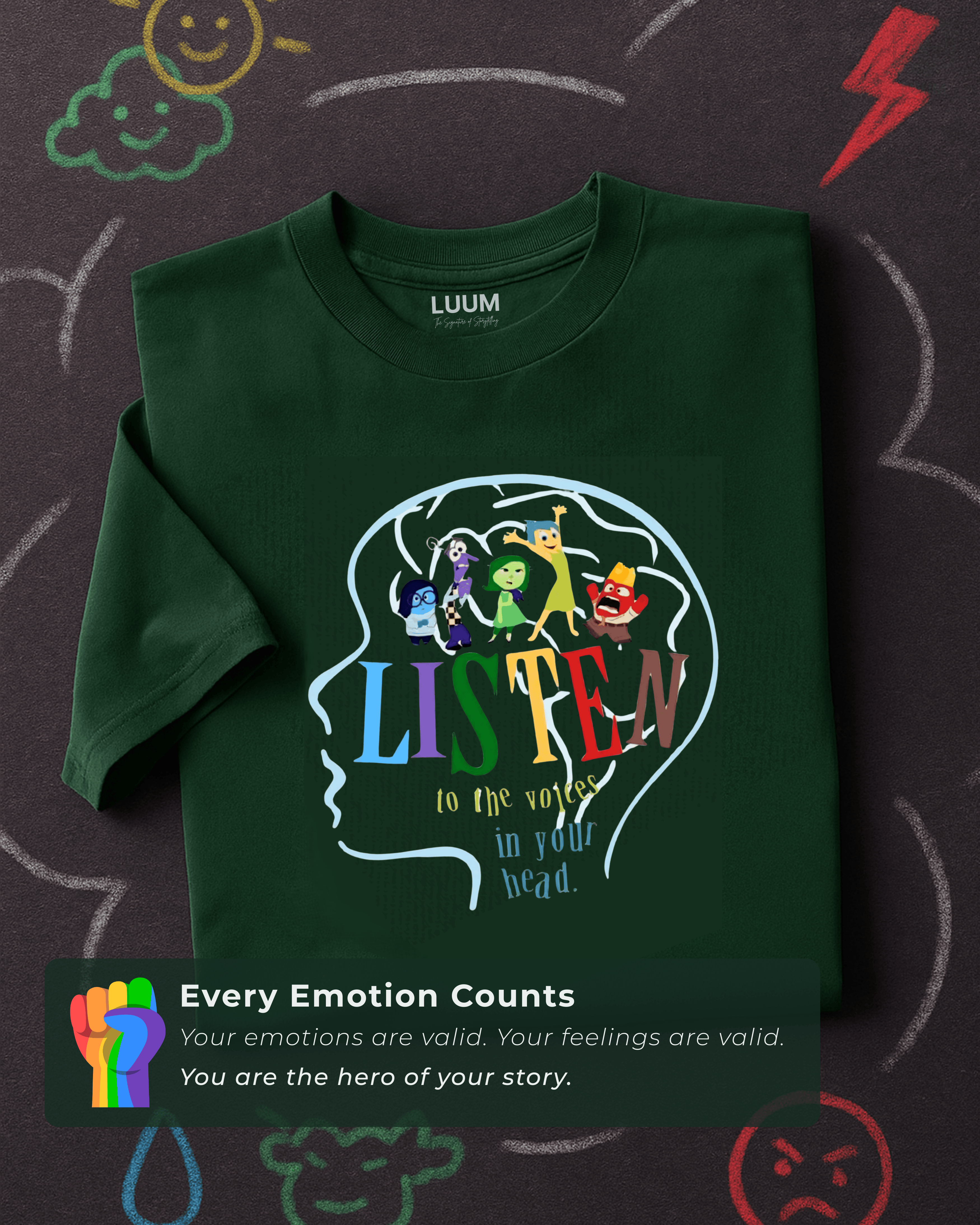 Folded LUUM's Every Emotion Counts t-shirt placed on chalkboard with doodles symbolizing emotions, creating a playful, expressive backdrop.Part of Threadmark Collection. Belief. Woven and Worn.