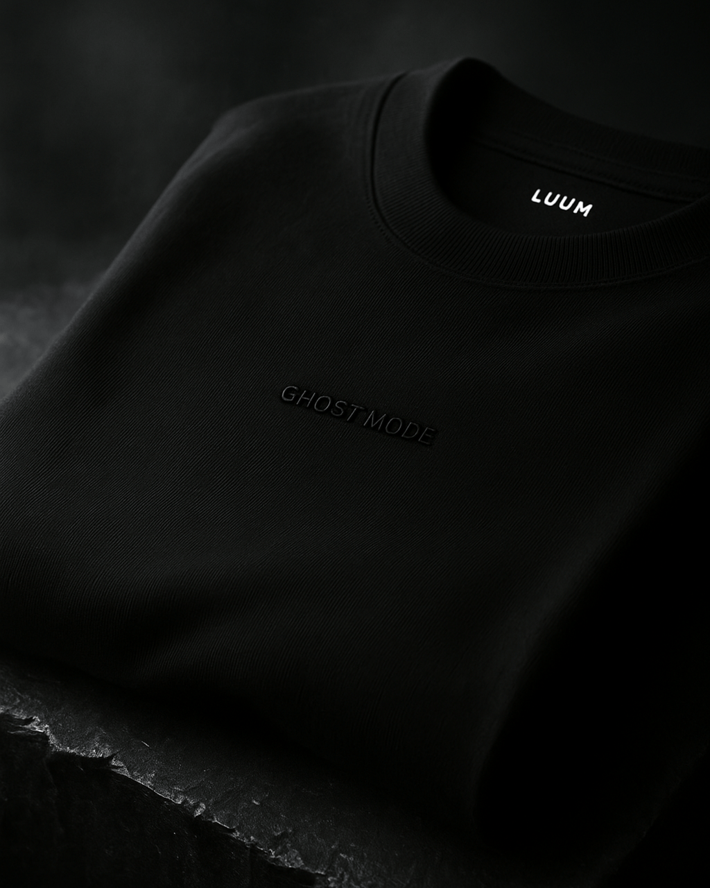 LUUM's Ghost Mode Close-up of black-on-black embroidery on Supima cotton. Part of Threadmark Collection. Belief. Woven and Worn.