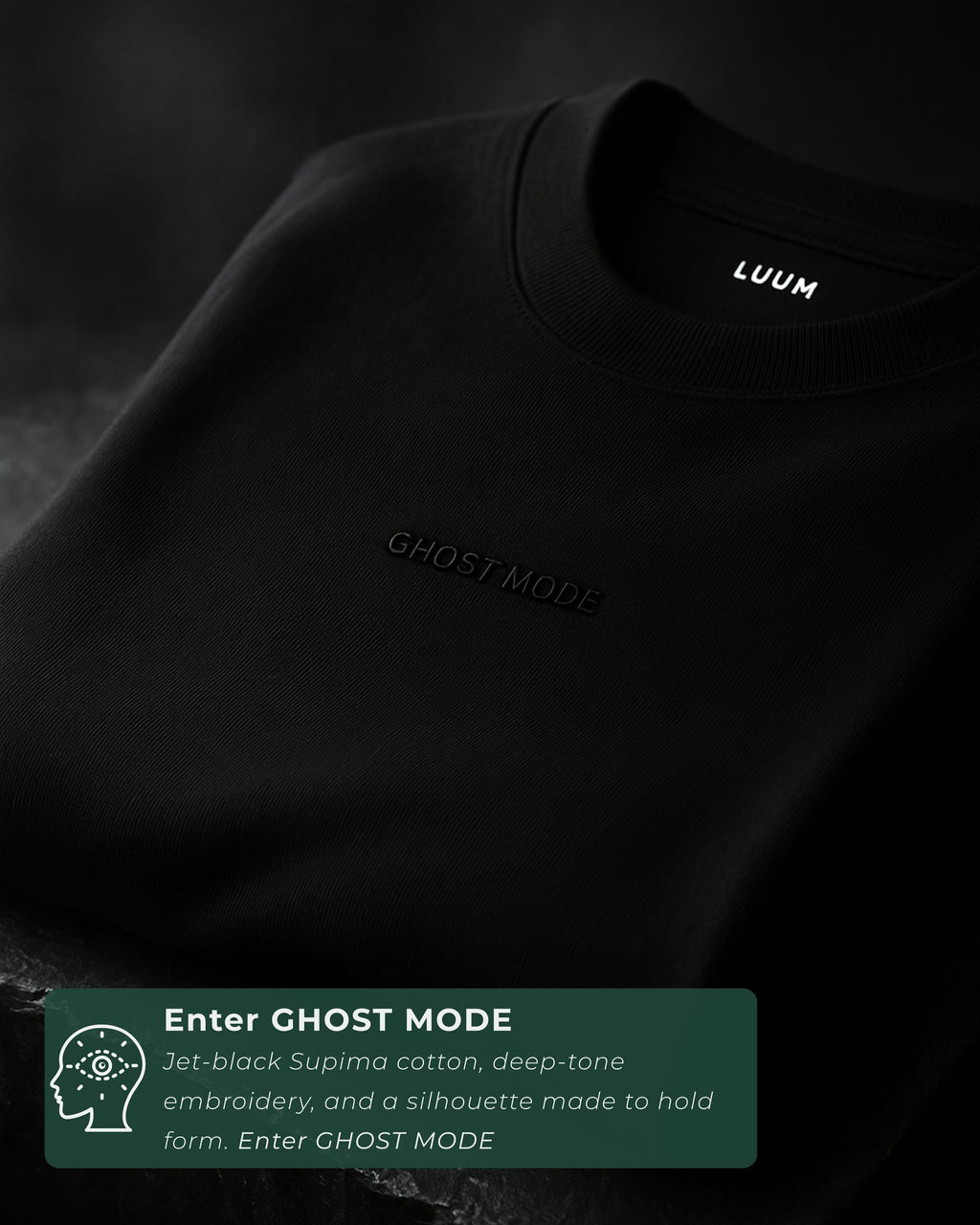 Folded cinematic shot of LUUM's black Ghost Mode tee with embroidered text visible. Part of Threadmark Collection. Belief. Woven and Worn.