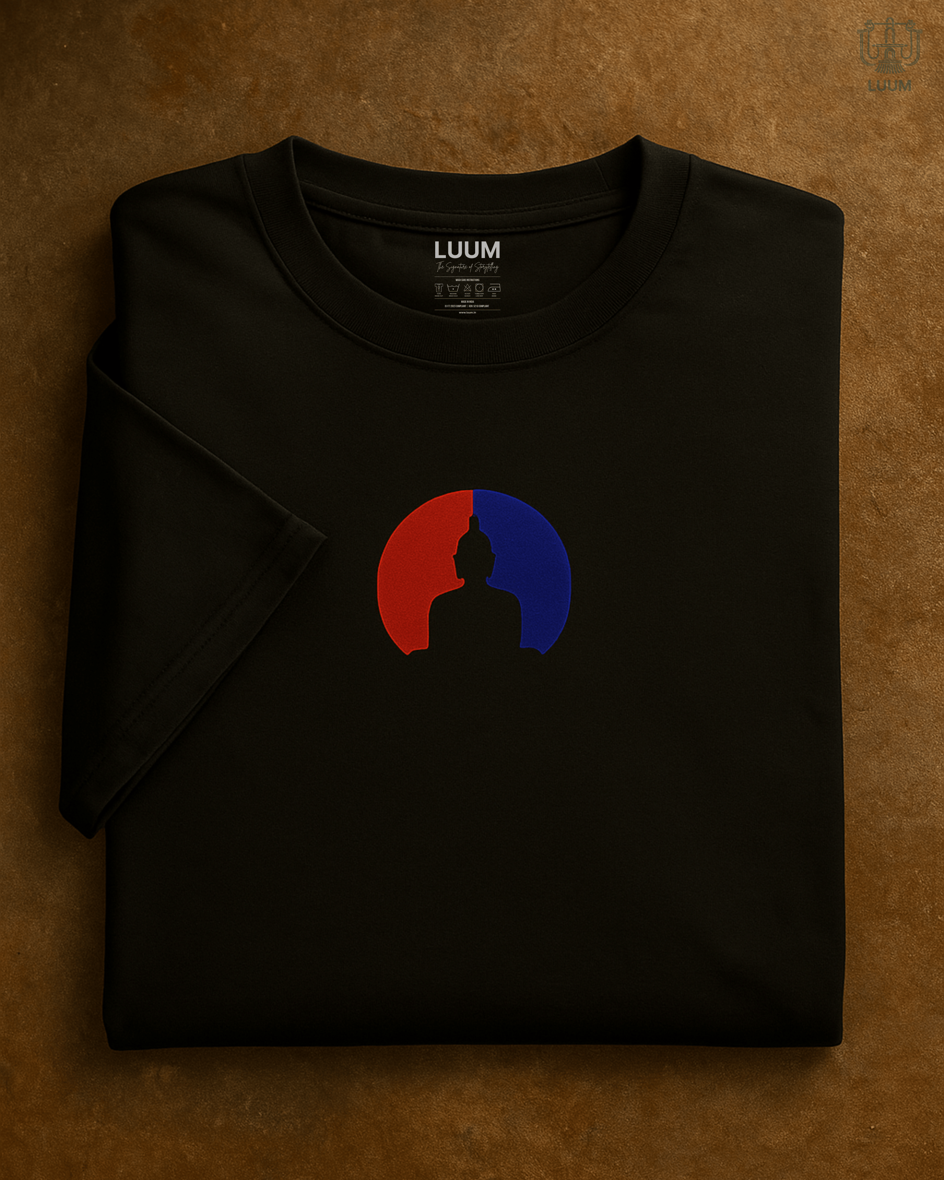 Front view of the LUUM's Samyak tee — black Supima cotton t-shirt with Buddha silhouette design in red and blue, symbolizing balance and focus. Part of Threadmark Collection. Belief. Woven and Worn.