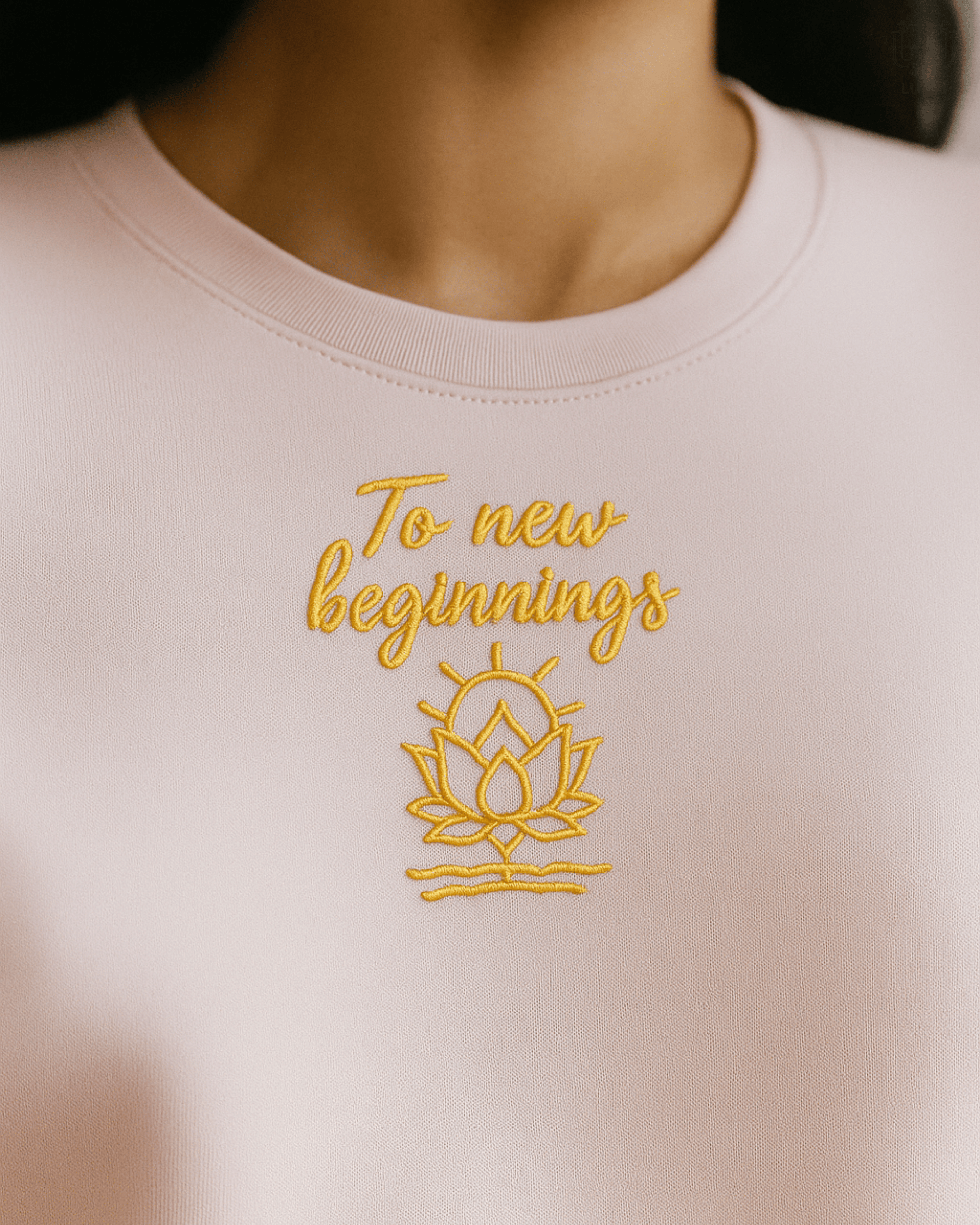 LUUM's Beige-gold lotus embroidery detail on Supima cotton fabric. Fine craftsmanship, renewal symbolism. To new beginnings. Part of Threadmark Collection. Belief. Woven and Worn.